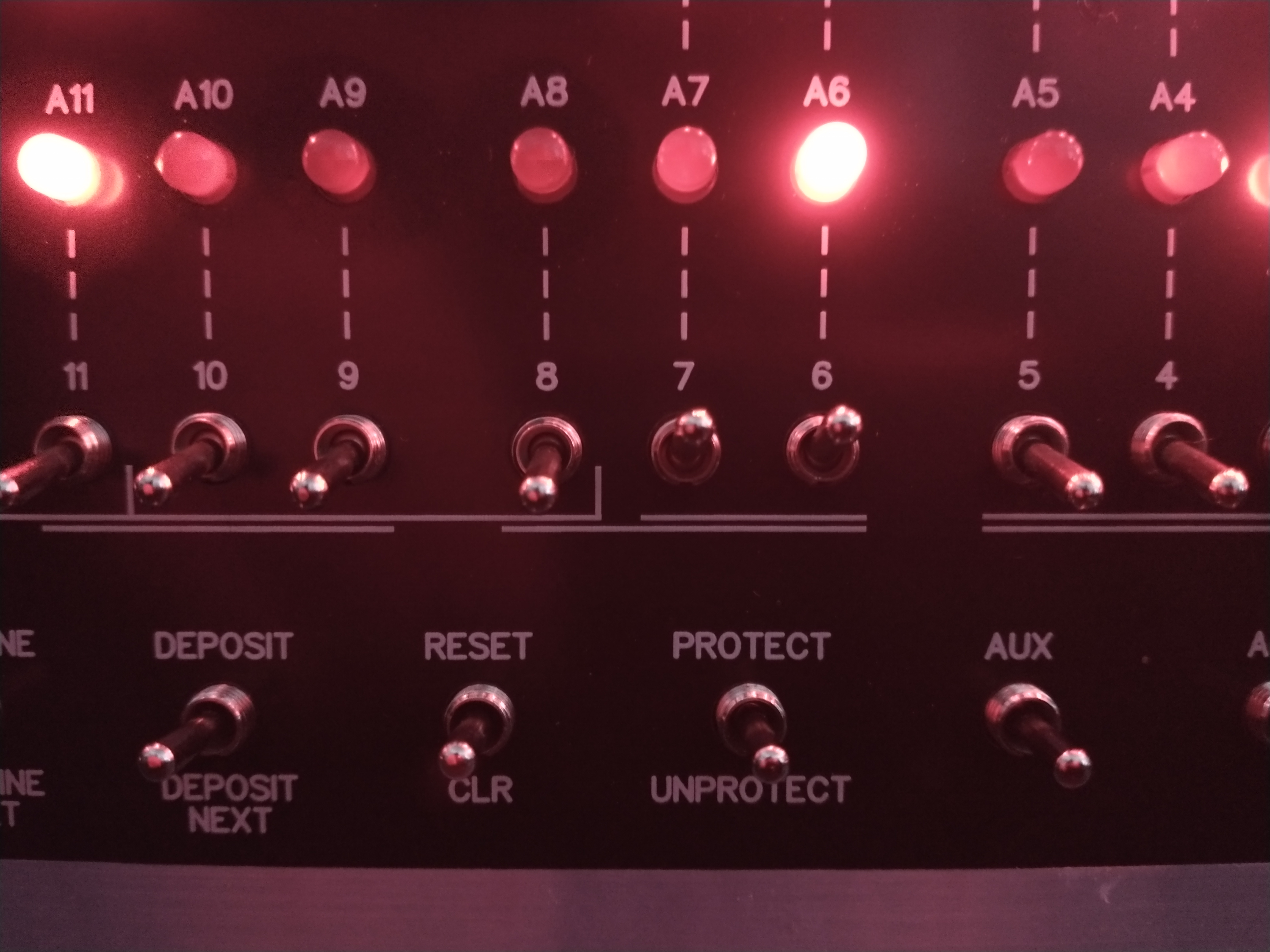 Closeup photo of the Altair 8800 mini front panel with a few red LEDs and corresponding switches below them in focus image